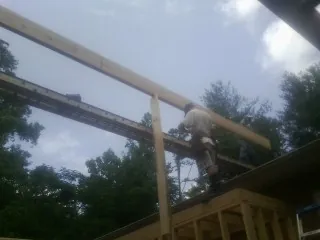 Carpenter setting a ridge beam over a new addition frame — Ice Dam Removal by Roofing Brothers in Moraga
