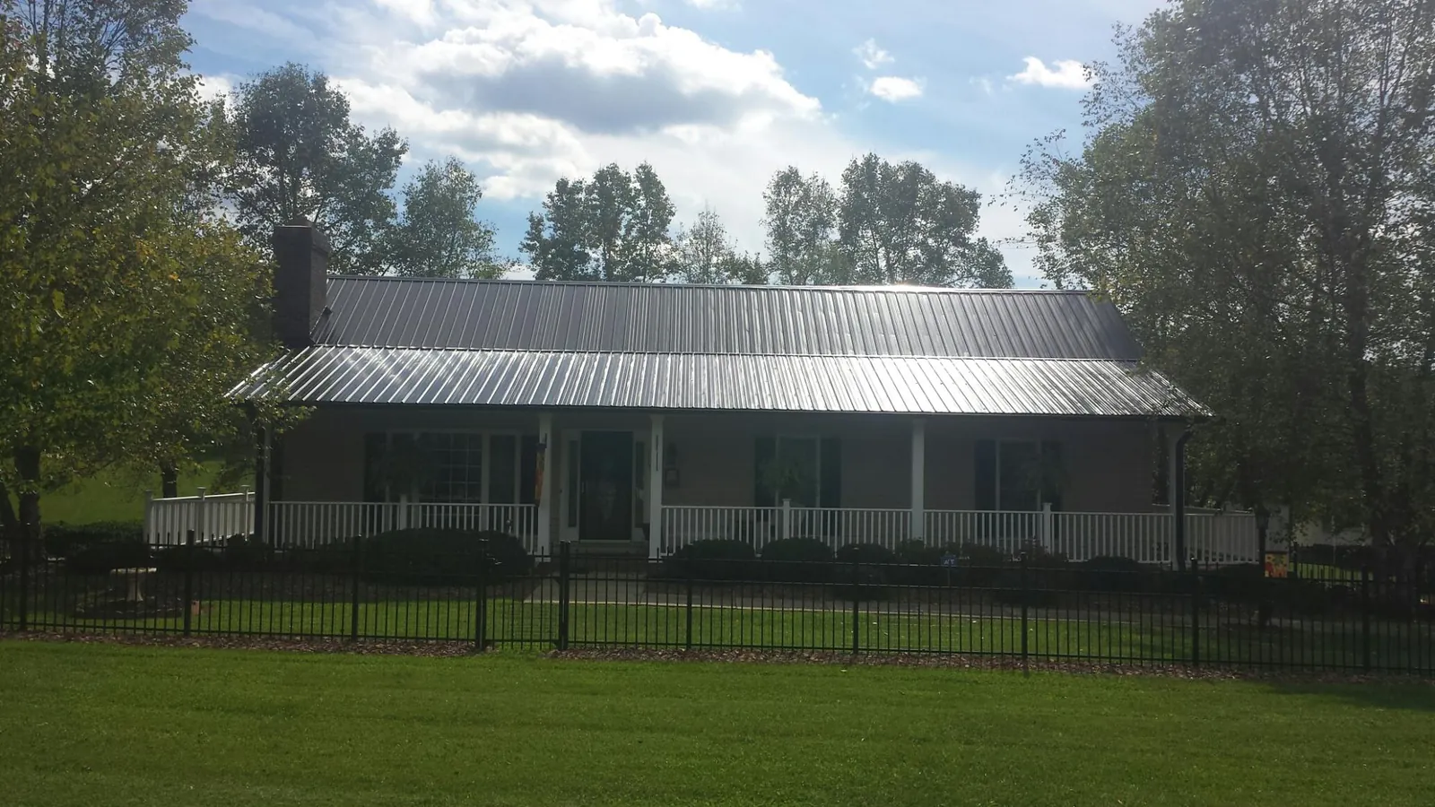 Gray metal roof on a brick ranch with a full width front porch — Gutter Guard Installation work by our crew in Moraga